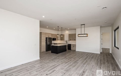 A spacious room with a kitchen island and pendant lights.
