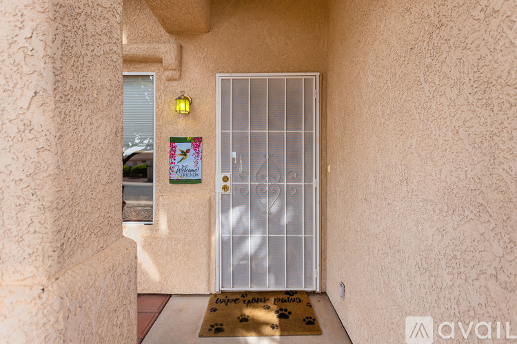 A house entrance with a closed gate and a doormat.