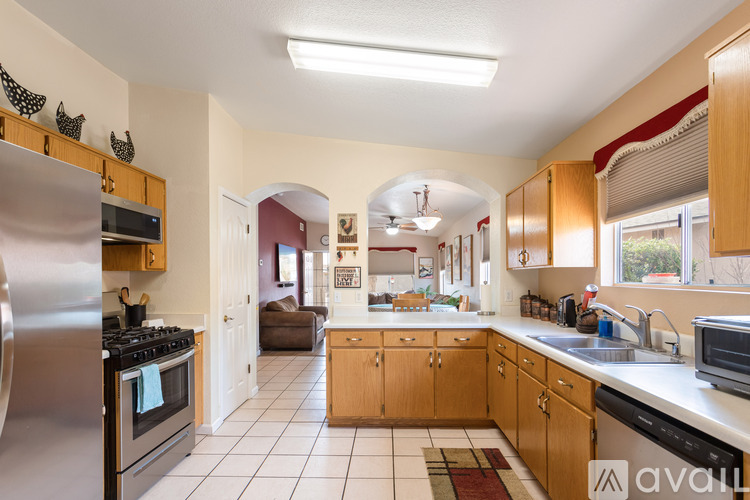 A kitchen with wooden cabinets and a stainless steel refrigerator.