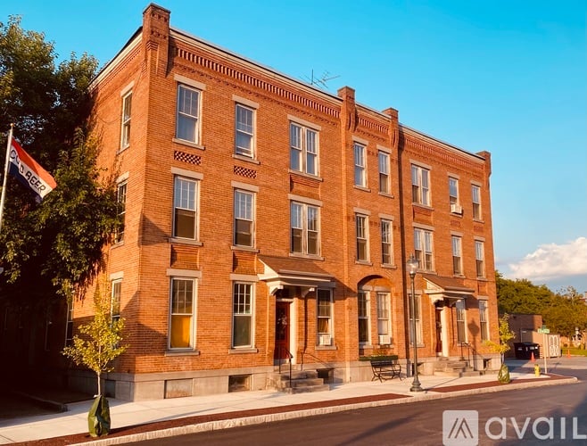 A red brick building with a flag on the left side.