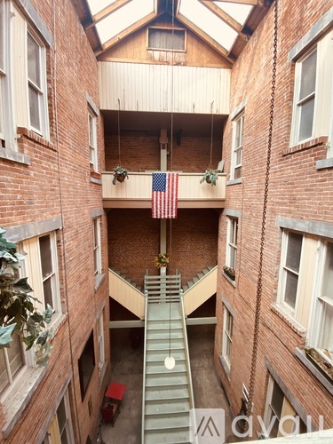 A view from above of a staircase leading to a balcony with an American flag hanging from it.