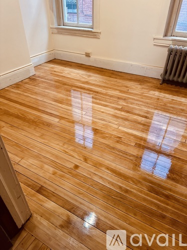 A room with wooden flooring and a window.
