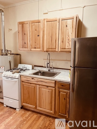 A kitchen with wooden cabinets and a stainless steel refrigerator.