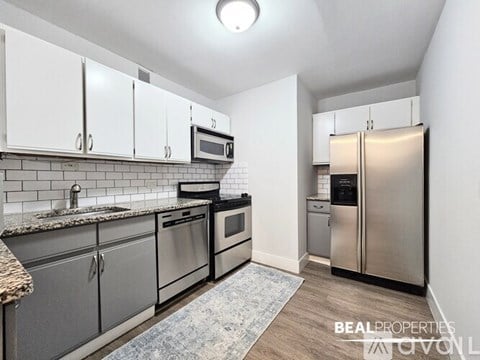 A kitchen with white cabinets and stainless steel appliances.