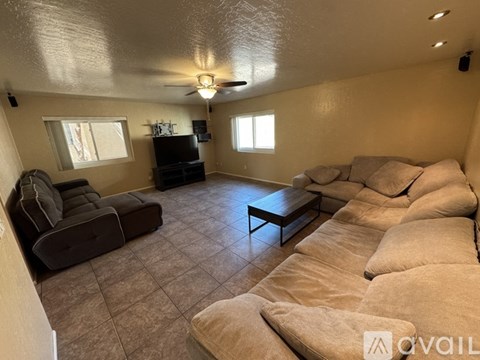 A living room with a brown couch and a black television.