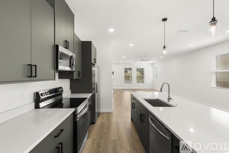 A kitchen with a white counter and green cabinets.