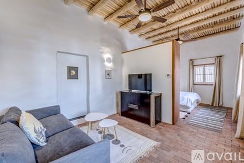 A living room with a grey couch and a wooden ceiling fan.