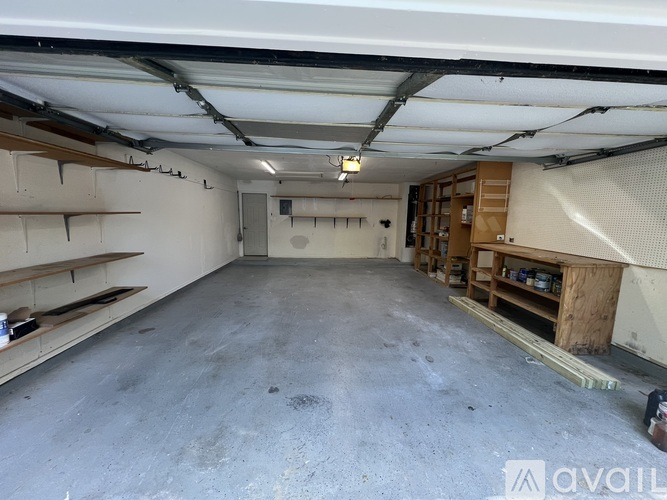 A spacious garage with a concrete floor and a white ceiling with exposed pipes.