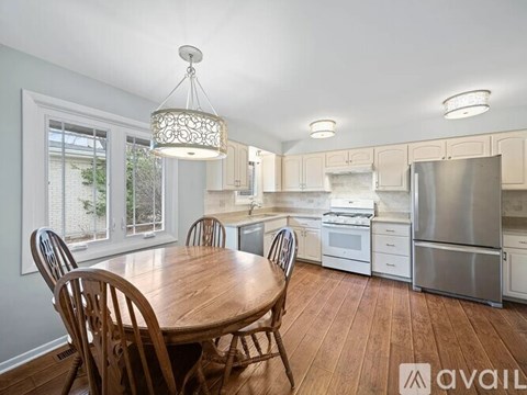 A kitchen with a table and chairs in front of a window.