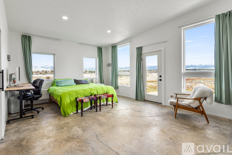 A bedroom with a bed, desk, and chair.
