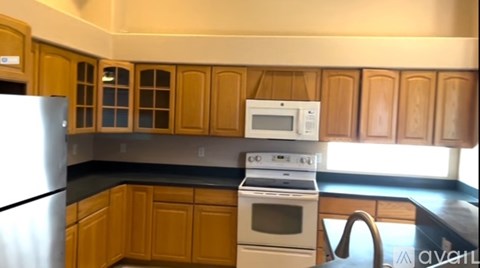 A kitchen with wooden cabinets and a white refrigerator.