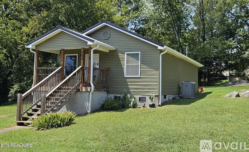 A house with a porch and a staircase leading to the entrance.