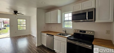 A kitchen with white cabinets and a black stove top oven.