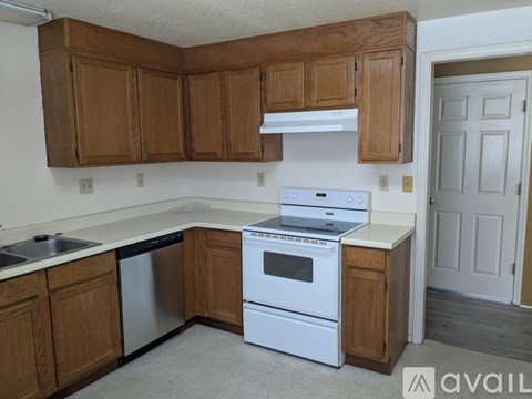 A kitchen with wooden cabinets and white appliances.
