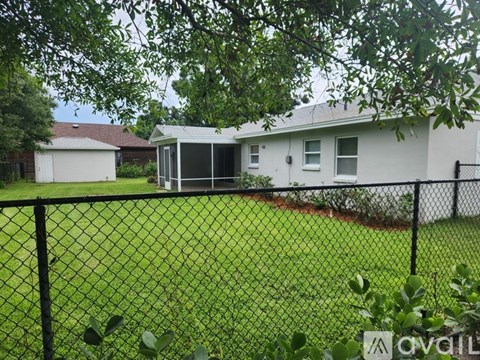 A house with a black fence and green grass in front.