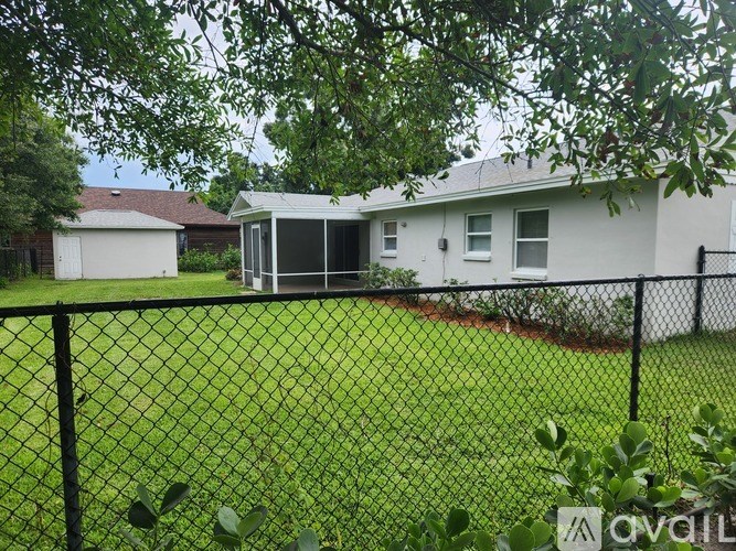 A house with a black fence and green grass in front.