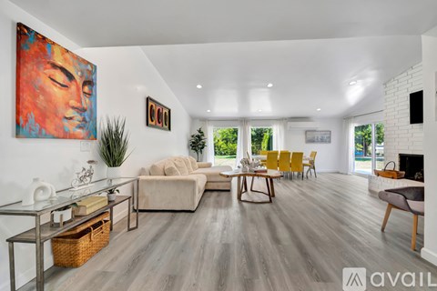 A living room with a large painting on the wall and a fireplace.
