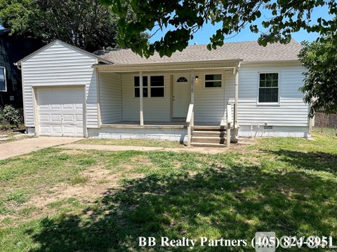 A white house with a garage is for sale.