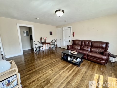 A living room with a brown leather couch and a black coffee table.