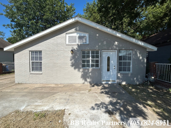 A small house with a white door and windows is for sale.