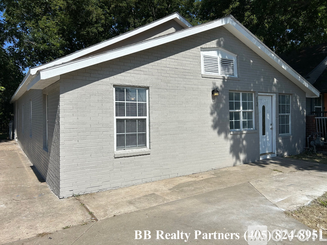 A small house with a BB Realty Partners sign in front.