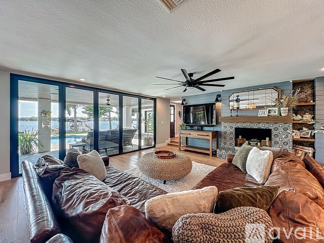 A living room with a brown leather couch and a fireplace.