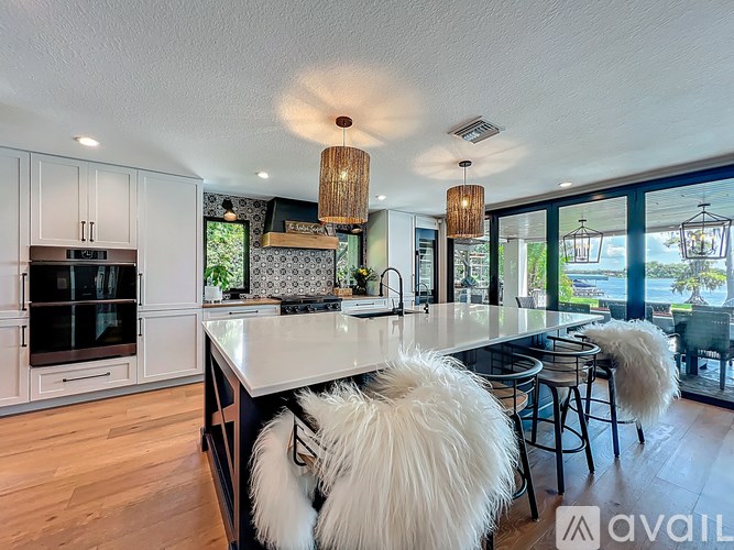 A modern kitchen with a large island and bar stools.