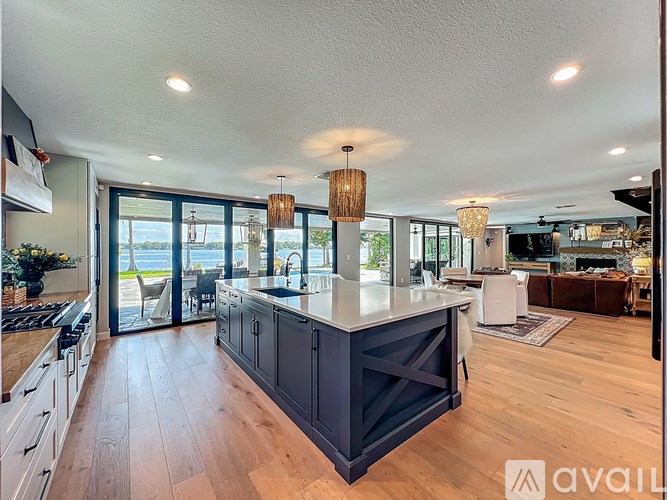 A modern kitchen with a large island and wooden floors.