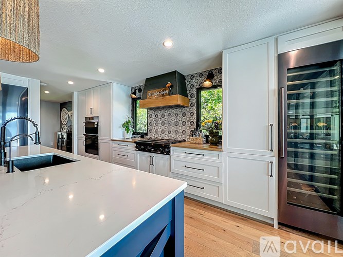 A kitchen with a marble countertop and stainless steel appliances.