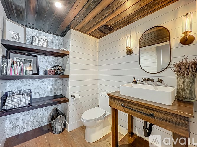A bathroom with a wooden vanity and a white toilet.