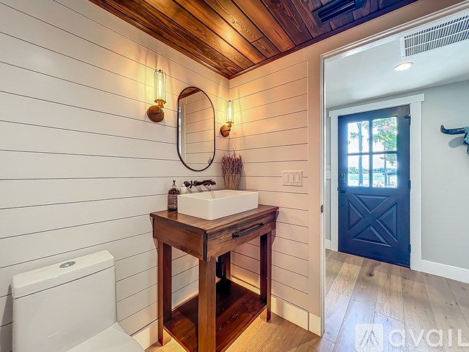A bathroom with a wooden vanity and a white toilet.