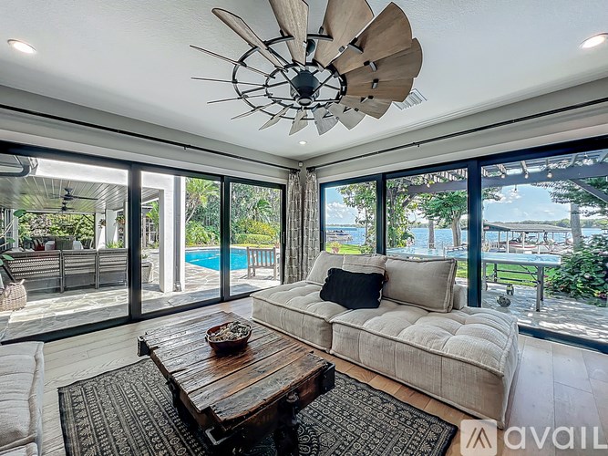 A modern living room with a large window overlooking a pool.
