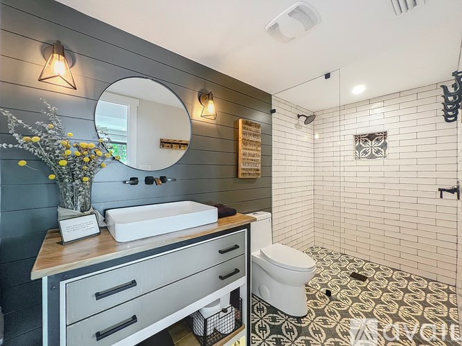 A bathroom with a white toilet and a mirror.