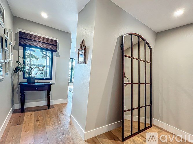 A room with a wooden floor and a window with blinds.