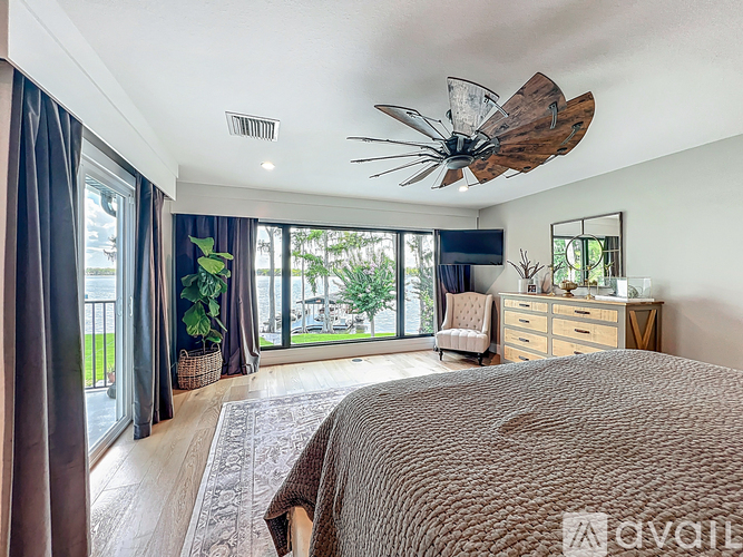 A bedroom with a large bed and a ceiling fan.