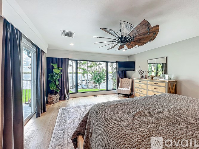 A bedroom with a large bed and a ceiling fan.