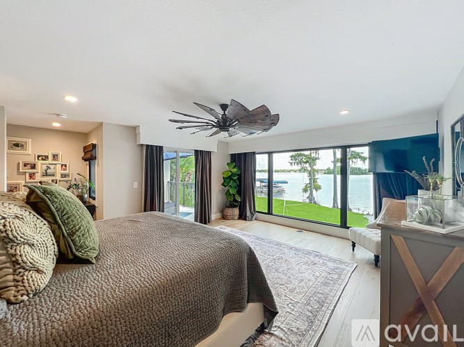 A bedroom with a large bed and a ceiling fan.