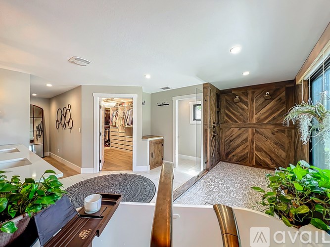 A modern living room with a large mirror and a wooden accent wall.