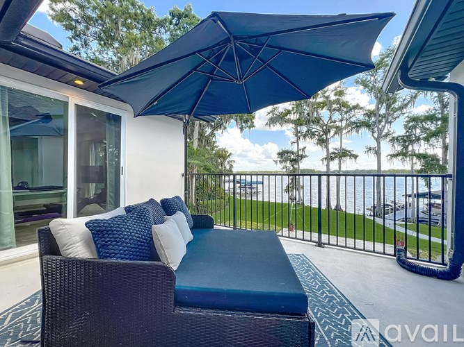 A blue patio umbrella is over a blue cushioned chair.
