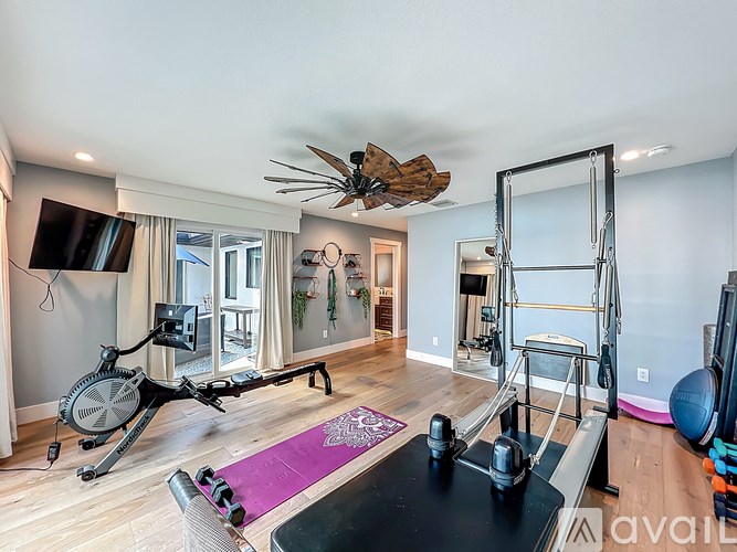 A home gym with a purple yoga mat on the floor.