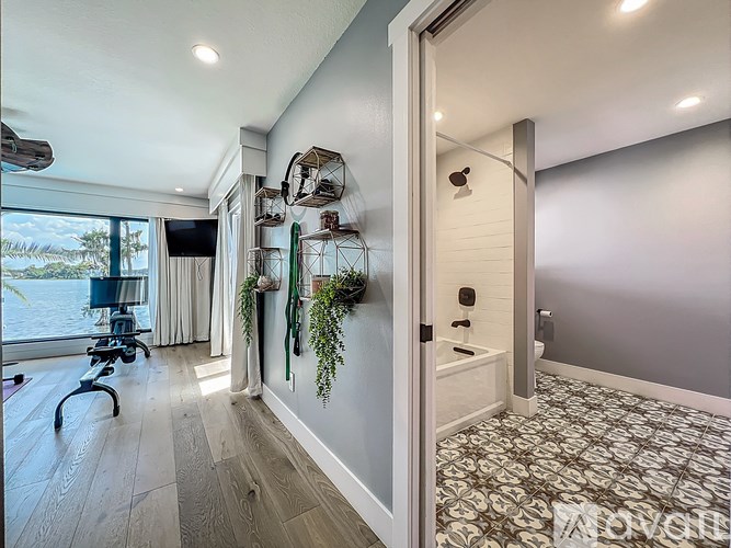 A hallway with a patterned floor and a doorway leading to another room.