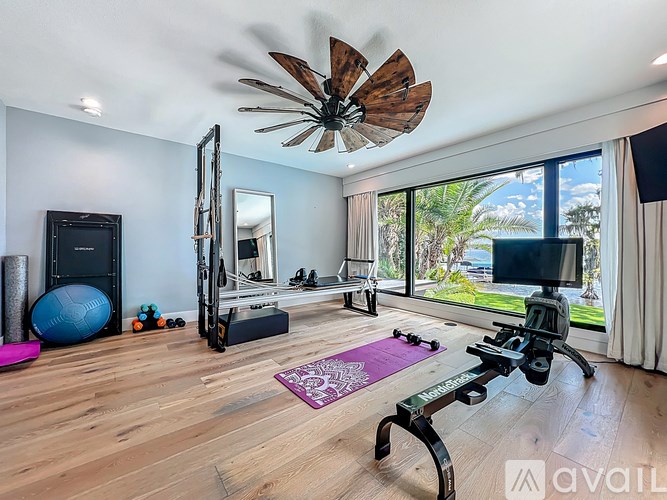 A room with a ceiling fan, exercise equipment, and a mirror.