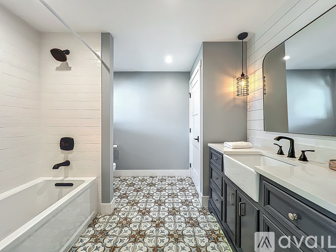 A bathroom with a patterned floor and a white sink.
