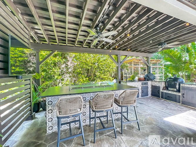 A patio with a table and chairs under a roof.