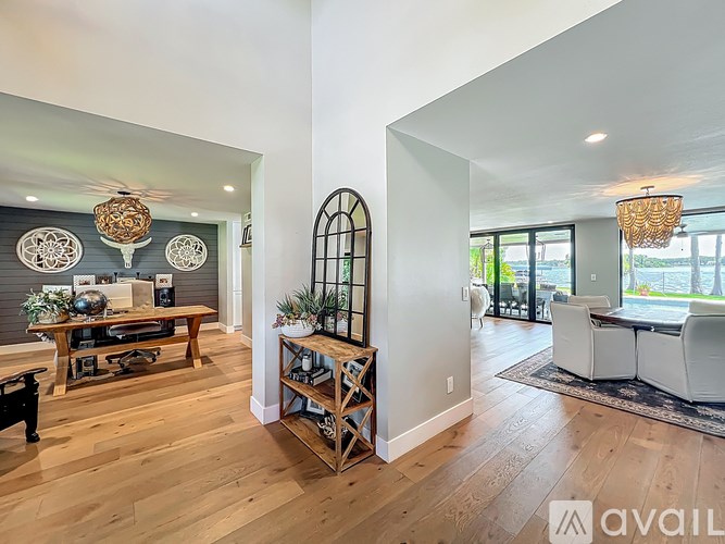 A living room with a wooden floor and a large window.