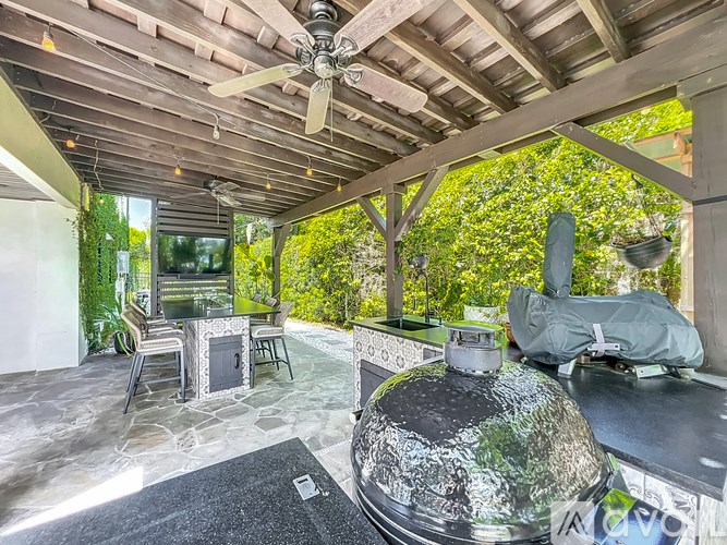 A patio with a table and chairs and a grill.
