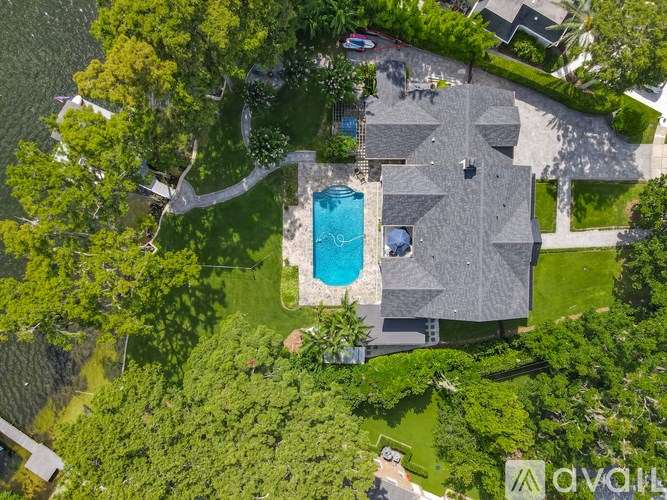 A house with a pool surrounded by trees.