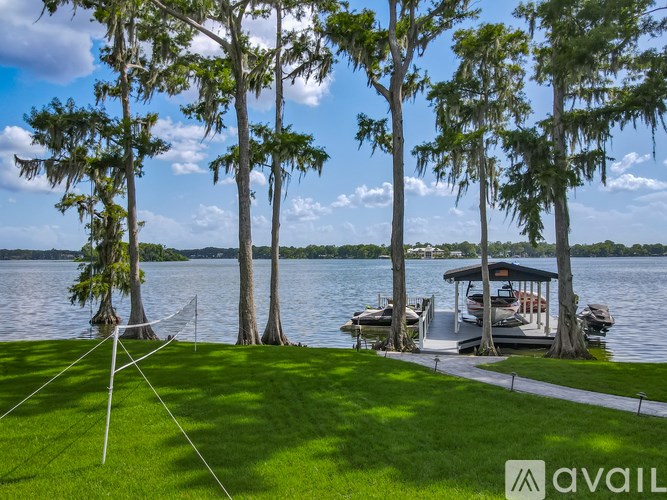 A lake surrounded by trees with a dock and a gazebo.
