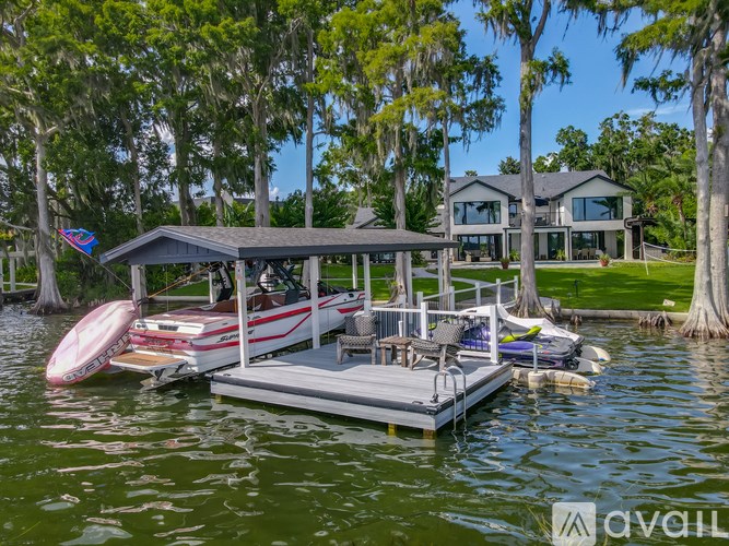 A house is situated on the water with a boat docked in front.