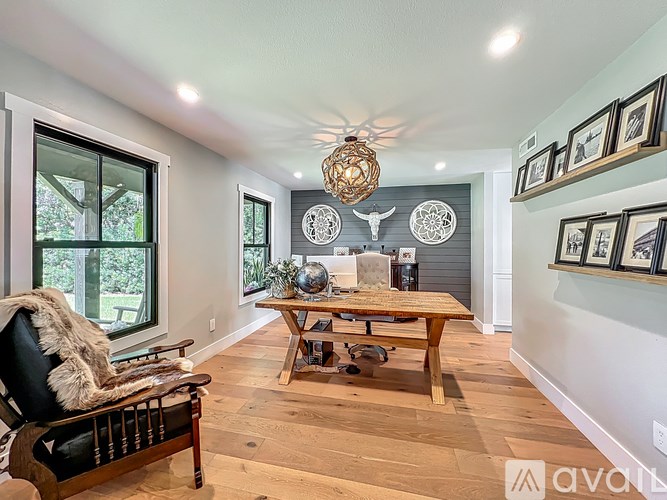 A living room with a wooden floor and a large window.